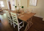 Brown Wooden Dining Table With Four Padded Chairs Inside Room with Beige Painted Walls