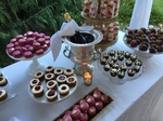 A bottle of Champagne among sweets at an event catering - Wedding Catering Menu Seattle by Christie's Catering
