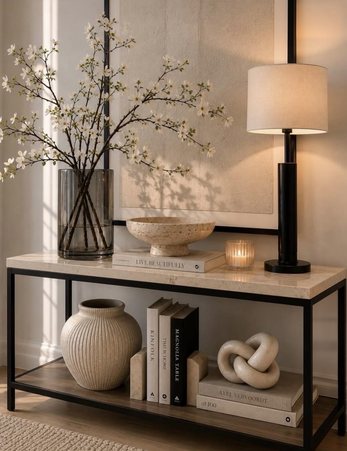 Styled entry console with blossoms, lamp and books
