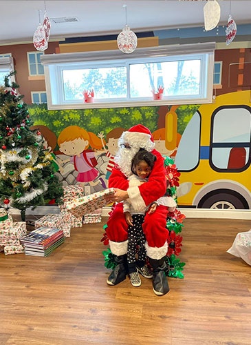 Santa giving Adi gifts for christmas at HIDE ‘n' SEEK DAYCARE - Preschool in Brampton, Ontario