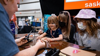 Photo by Darkstrand Visuals of a person demonstrating a device to a child at a children's gathering