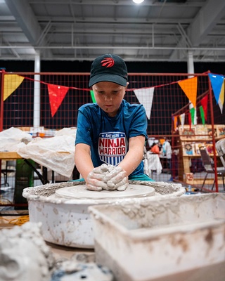 Darkstrand Visuals took a picture of a young child creating something out of clay at an event