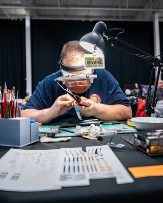 Photo taken by Darkstrand Visuals of an individual repairing a device at an electronic fair event