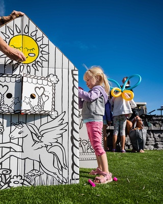 A cute little girl painting on the paper house at the event photo captured by Darkstrand Visuals