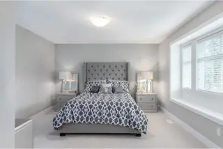 Step into the cozy bedroom interior within Towns At Trafalgar, a townhome collection by Noura Homes.