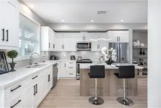 The contemporary elegance of the white kitchen interior within Towns At Trafalgar, a townhome collection by Noura Homes