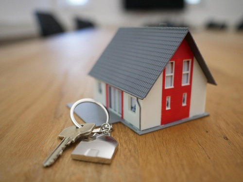 A keychain besides a small house model