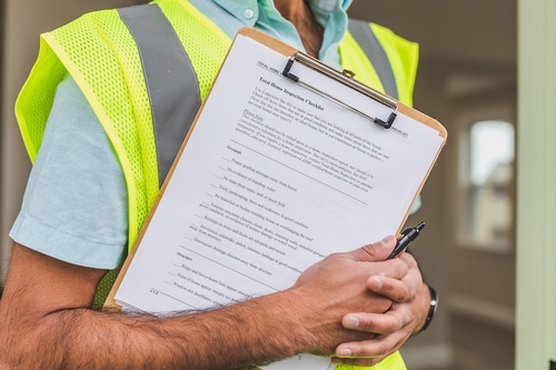 A home inspector holding a home inspection checklist