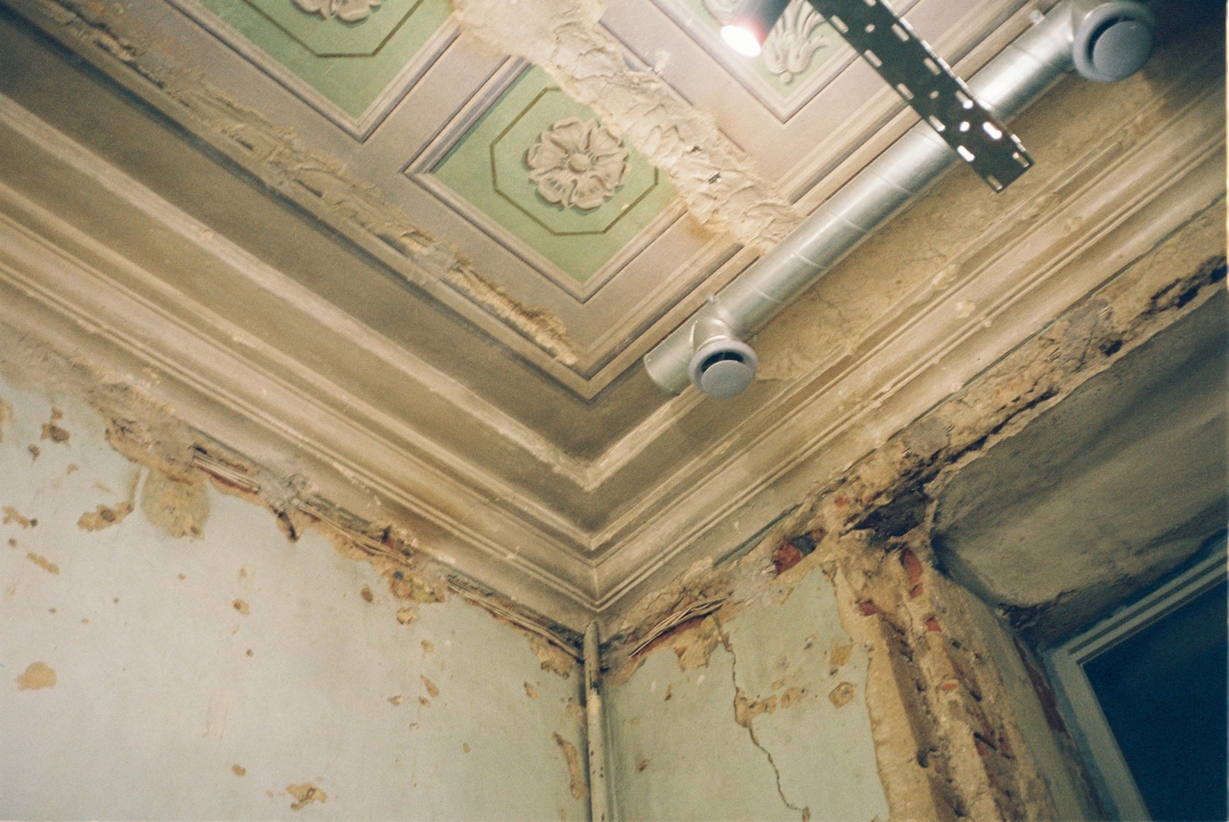 A ceiling with much damage and mold