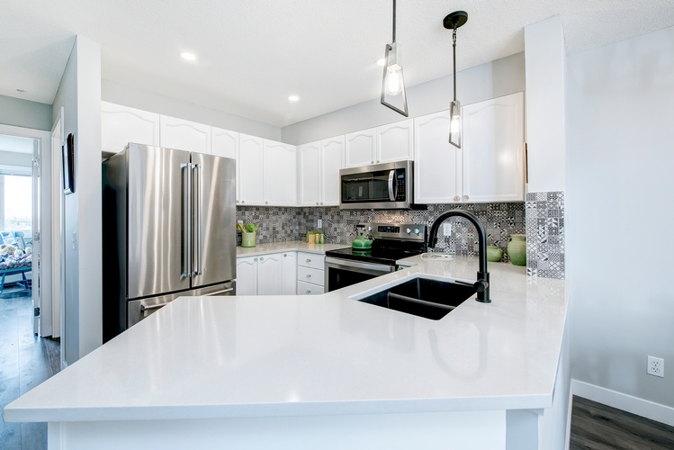 WITH LIMITED SPACE IN THIS CONDO KITCHEN, WHITE IS THE BEST COLOUR TO USE, IT GIVES THE APEARANCE OF A BIGGER SPACE. THE NEW MODERN LIGHT FIXTURES ALSO CONTRIBUTE TO THE TRANSFORMATION.