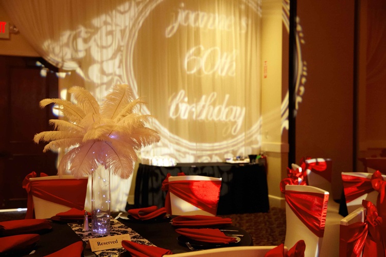 Close-up of the 60th birthday sign with sparkling red and gold lights organized by Houston Event Planning