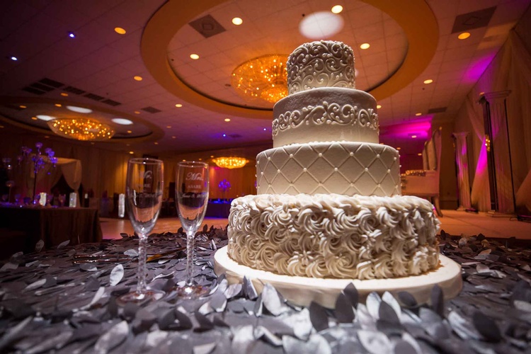 Wedding champagne glasses and cake with floral decoration done by Houston Event Planning