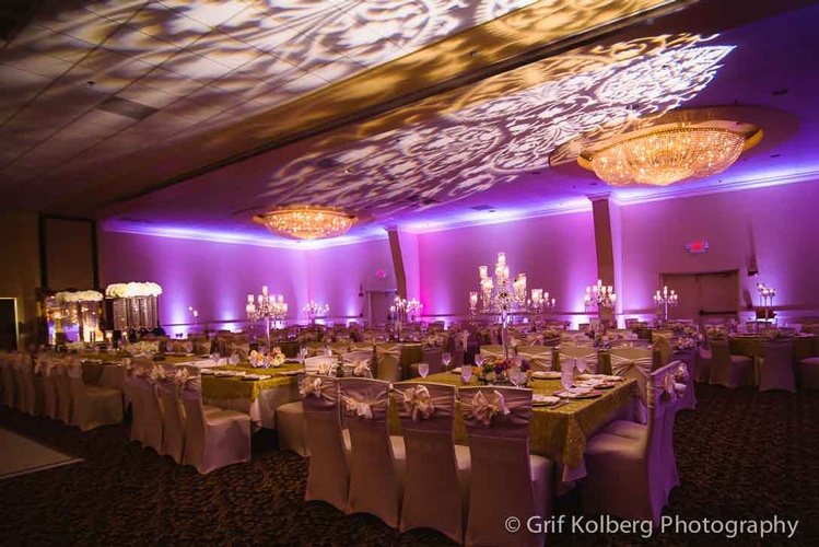 Beautiful wedding reception table setup with chandeliers and drapery done by Houston Event Planning