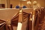 Beautiful table setting with chairs decked in golden fabric as a bow organized by Houston Event Planning