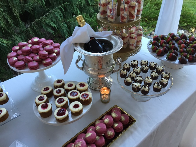 A bottle of Champagne among sweets at an event catering - Wedding Catering Menu Seattle by Christie's Catering