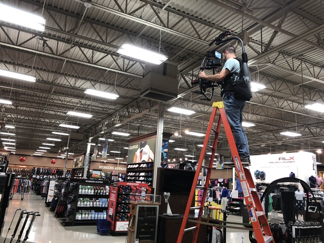 Videographer Standing on a ladder to shoot a video