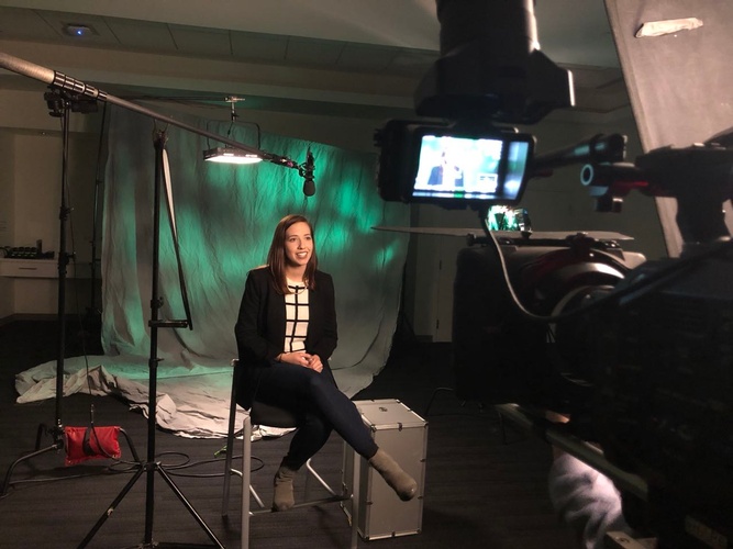 Interview of a woman in a dark studio being shot by Merlin Productions LLC 