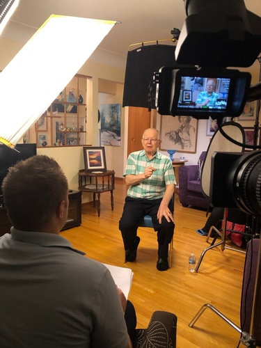Interview of an old person being recorded by Merlin Productions LLC Videographer
