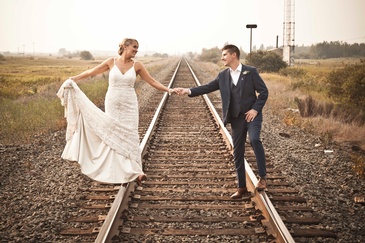 Couple holding Hands on a Railway Track captured by Edmonton Photographer at Artistic Creations Photography and Video