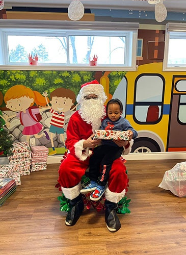 Santa giving Jayseh gifts for christmas at HIDE ‘n' SEEK DAYCARE - Day Care Center in Brampton, Ontario