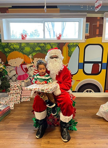 Santa giving Noah gifts for christmas at HIDE ‘n' SEEK DAYCARE - Licensed Childcare Center in Brampton