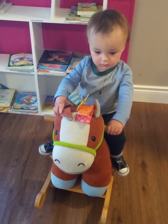 Child riding a soft toy horse at HIDE ‘n' SEEK DAYCARE - Day Care Center in Brampton, Ontario
