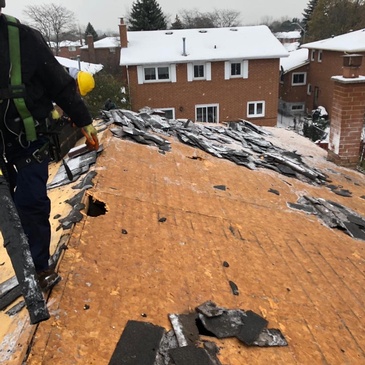 Expert roofer of Imperial Roofs and Aluminum repairing the damaged roof of a house in a snowy region