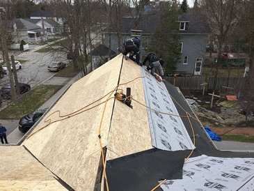 Expert roofers repairing the roof of residential property by Imperial Roofs and Aluminum