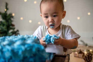 Portrait photography of an infant enjoying taste of cake captured by Flores Photography