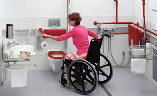 A handicapped woman comfortably using a barrier-free washroom installed by Integral Konnect 