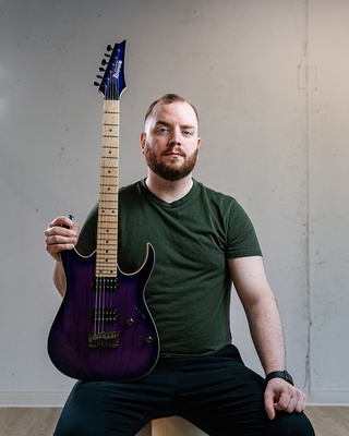 A man posing with his guitar high quality portrait photographed by Darkstrand Visuals