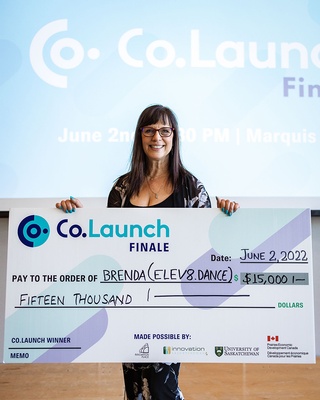 Brenda displaying a cheque she received from the company photo by Darkstrand Visuals