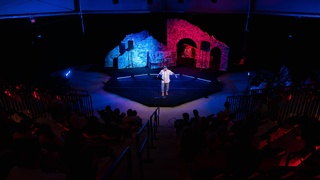 A young guy performing in front of a sizable audience photographed by Darkstrand Visuals.