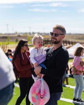 Picture taken by Darkstrand Visuals of a man holding her adorable young daughter at a children's event