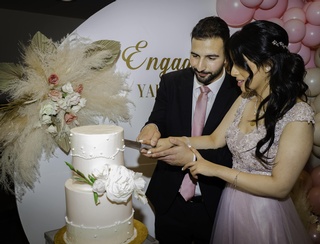 Engagement Portrait of a beautiful couple cutting cake captured by Guava Productions in Edmonton