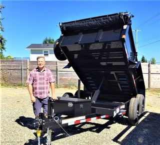 A satisfied customer with a heavy-duty dump trailer from Pacific Rim Trailer Sales