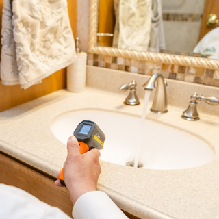 Professional inspector using a thermal device to inspect a wash basin during a home inspection