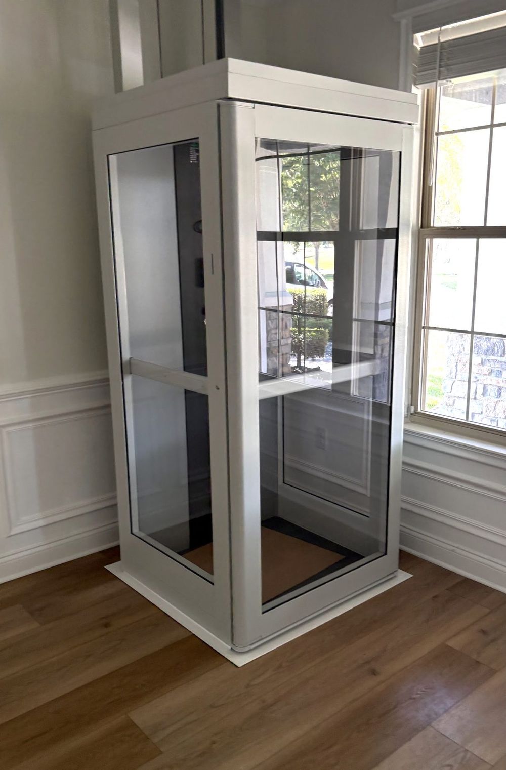 White shaftless glass home elevator installed in a Winter Garden, Florida home by Florida Home Elevators