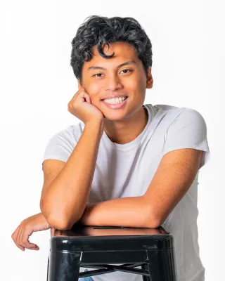 Professional studio portrait of a smiling young man in a white T-shirt