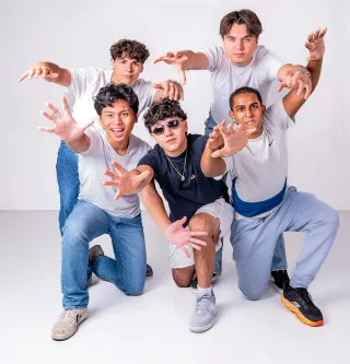 Creative group portrait of five young men posing in a professional photography studio