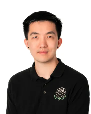 Professional headshot of a man in a black polo shirt against a white background.
