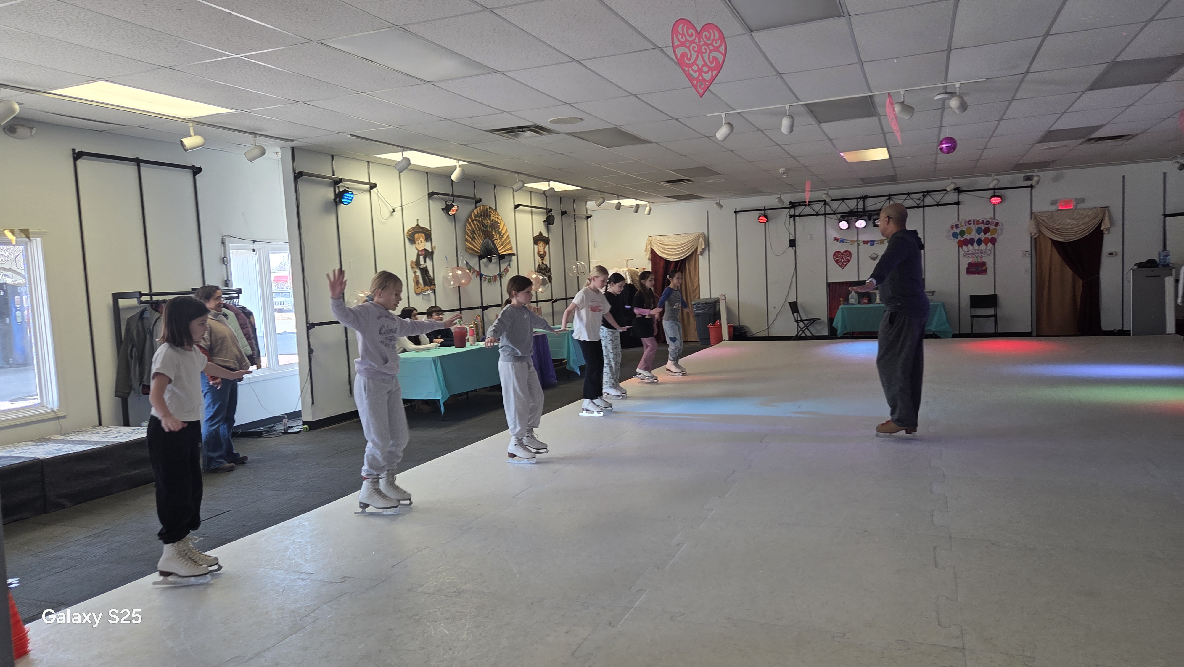 Instructor guiding students through synthetic ice skating classes